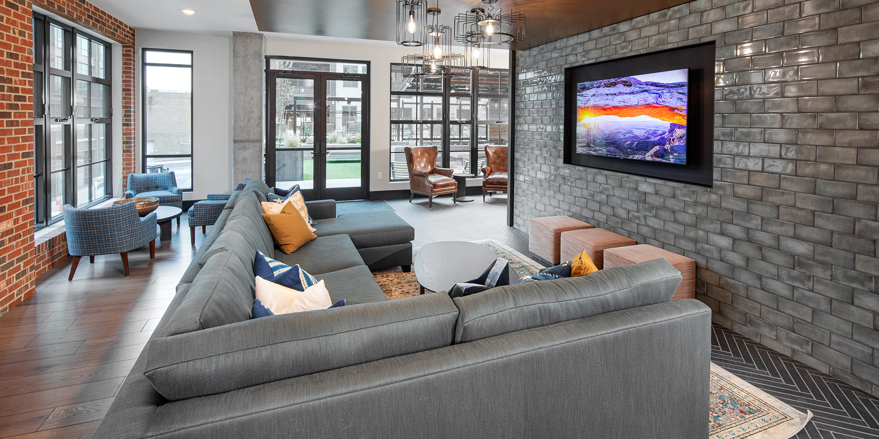 The Line clubroom featuring gathering TV, L sofa, and ottomans