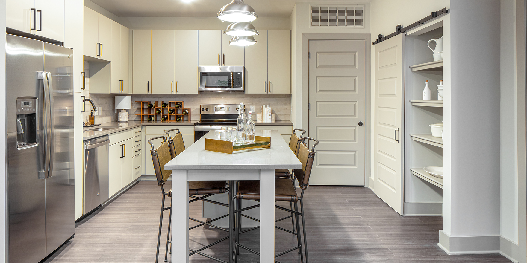 The Line two bedroom apartment kitchen with kitchen dining table/ island and farmhouse sliding door